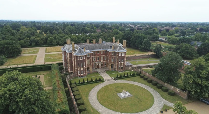 a large red and brown brick building in an enclosed area