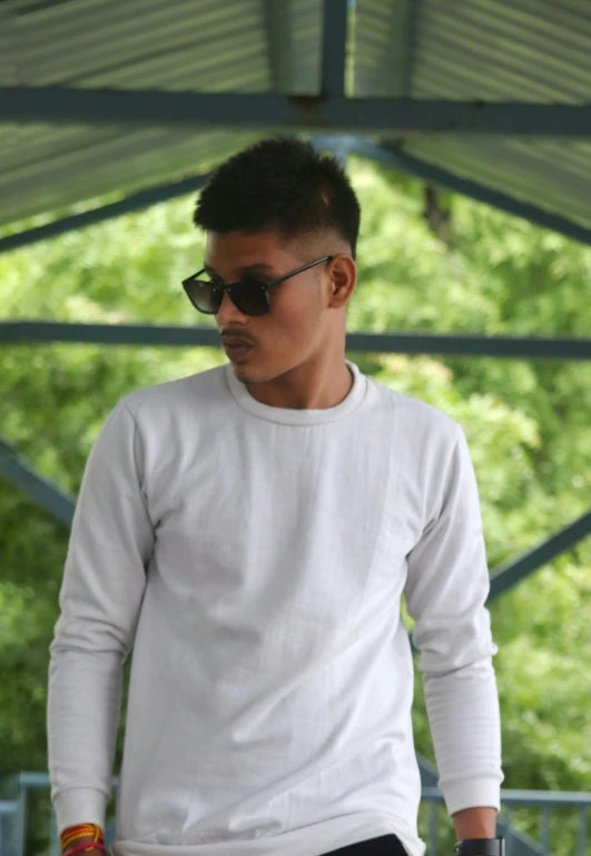 a man wearing a white sweater and sunglasses