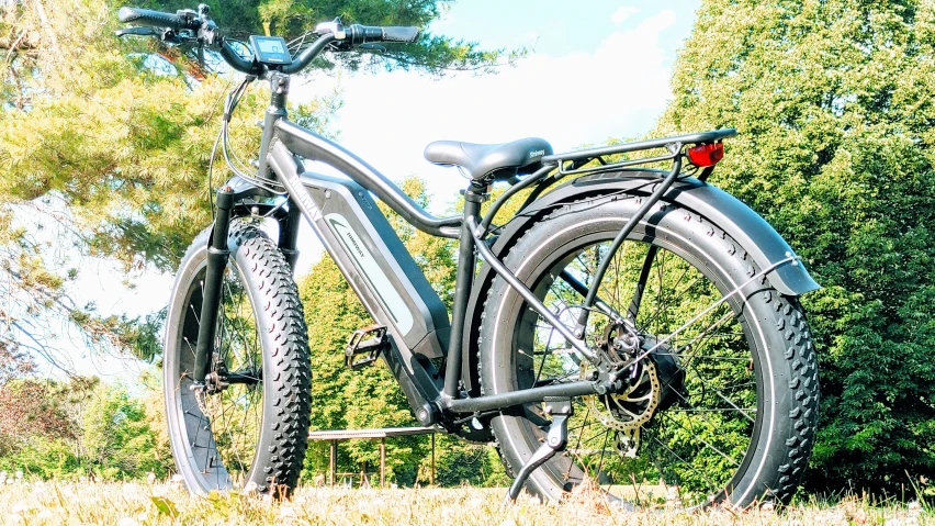 a black bike sitting next to a wooded area