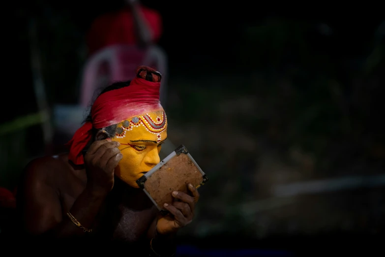 a person with yellow paint and red headscarves