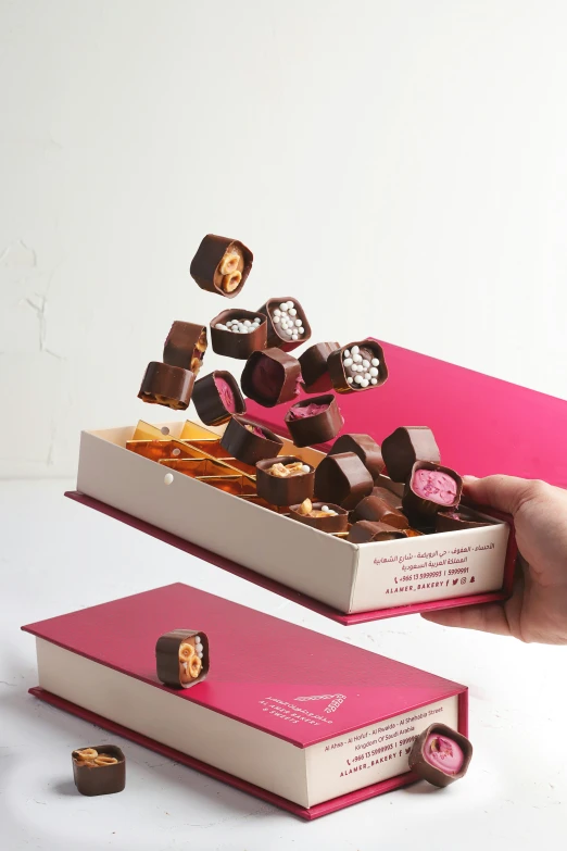 chocolates falling out of a box into a person's hand