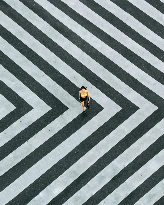 a man walking across a cross walk in the middle of nowhere