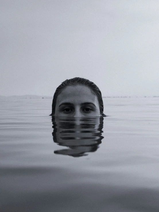 a woman floating in the water in a black and white po