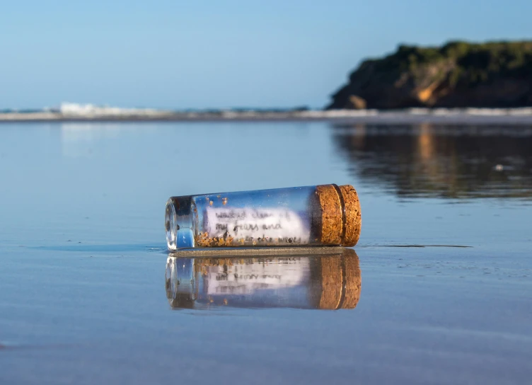 a message is placed in a bottle laying in the shallow water