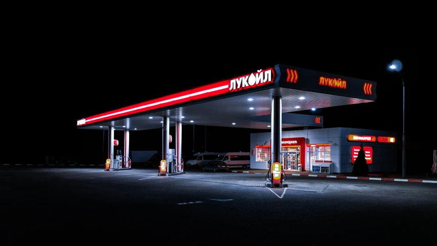 a large gas station at night with several service signs