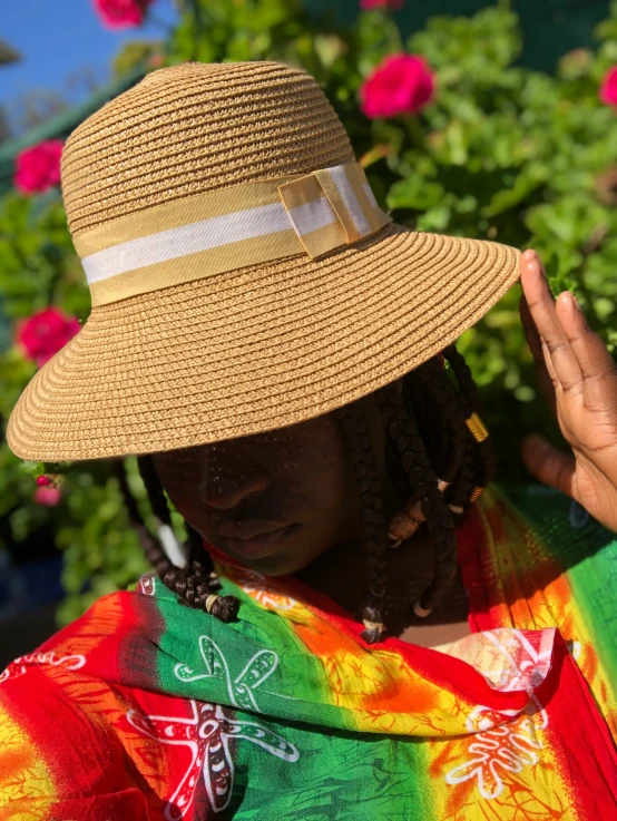 woman in a straw hat with floral shawl, hands and chest folded