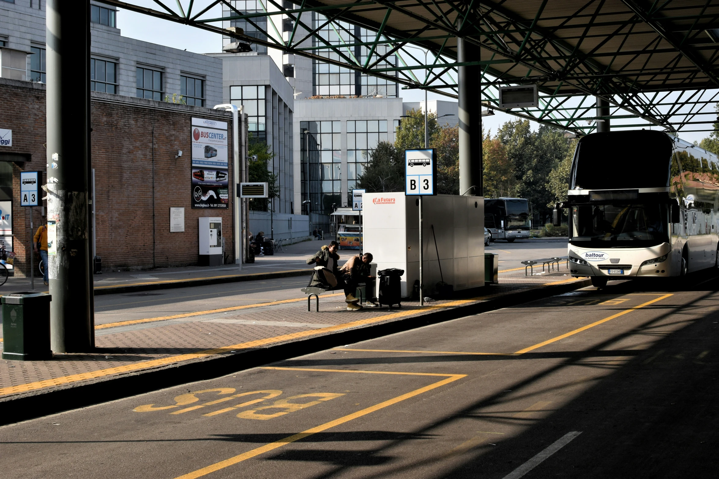 people sitting at a train station waiting to board