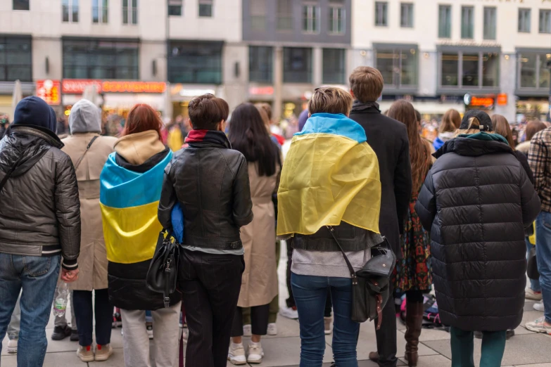 several people wearing colorful coats looking into a city