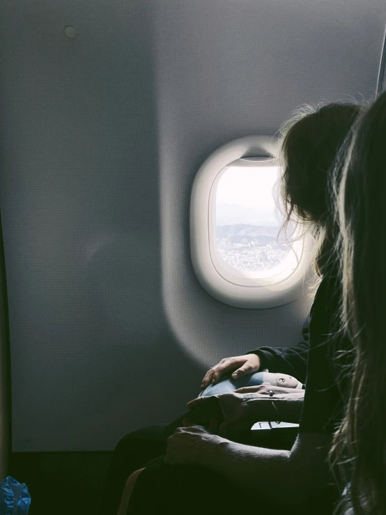 a woman looking out an airplane window on an airplane