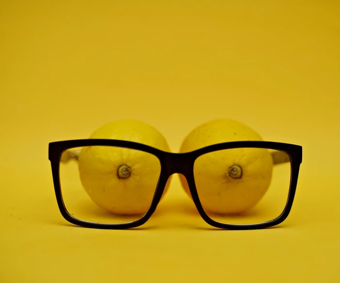 a pair of glasses that have a lemon under it