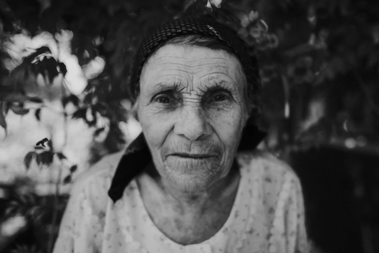 an old woman sitting outside in a tree