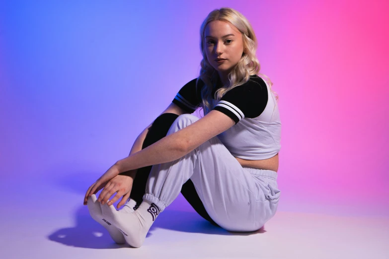 a beautiful blonde woman sitting on the ground