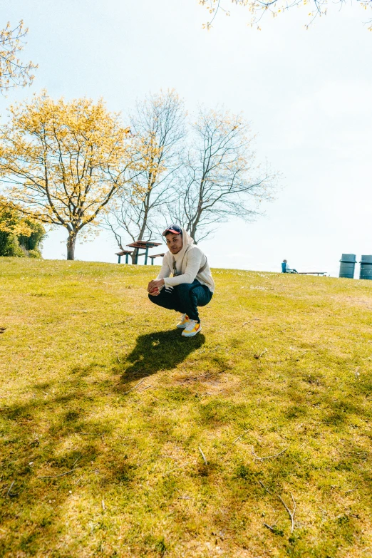 a man squatting in a field with a frisbee