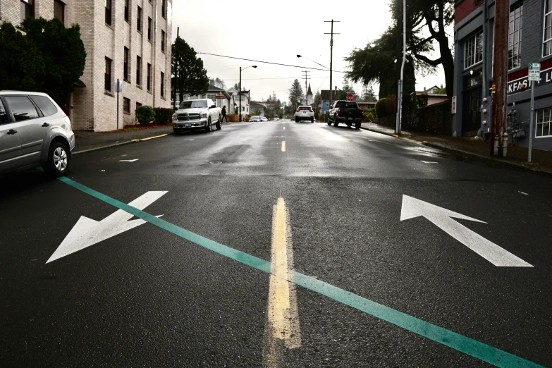 cars parked on the road with arrows on the street