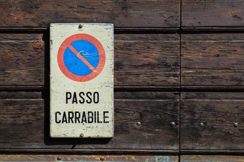 a sign is posted on an old wood panel