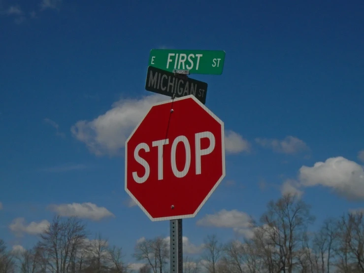 a stop sign with two street signs above it
