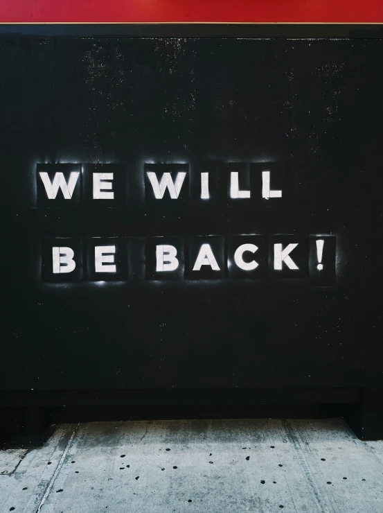 the words we will be back written on the side of a building