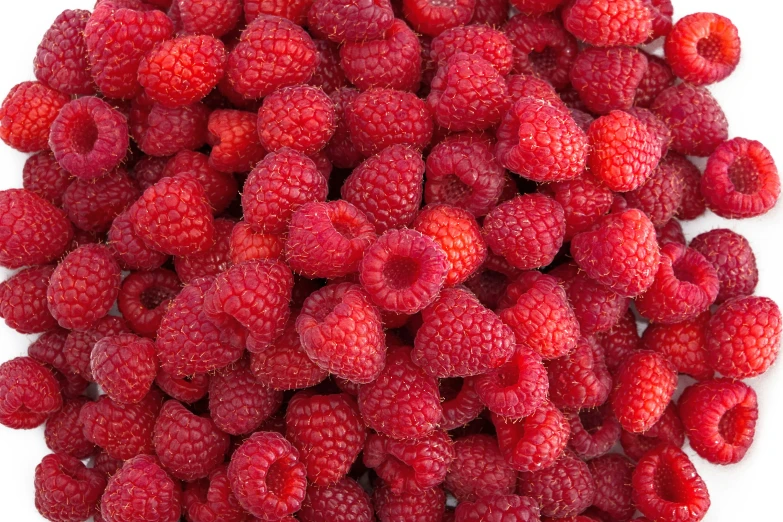 a pile of fresh raspberries sitting on top of a table
