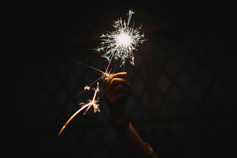 a person holding a sparkler with their hand