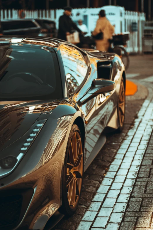 close up of a gold sports car with people outside