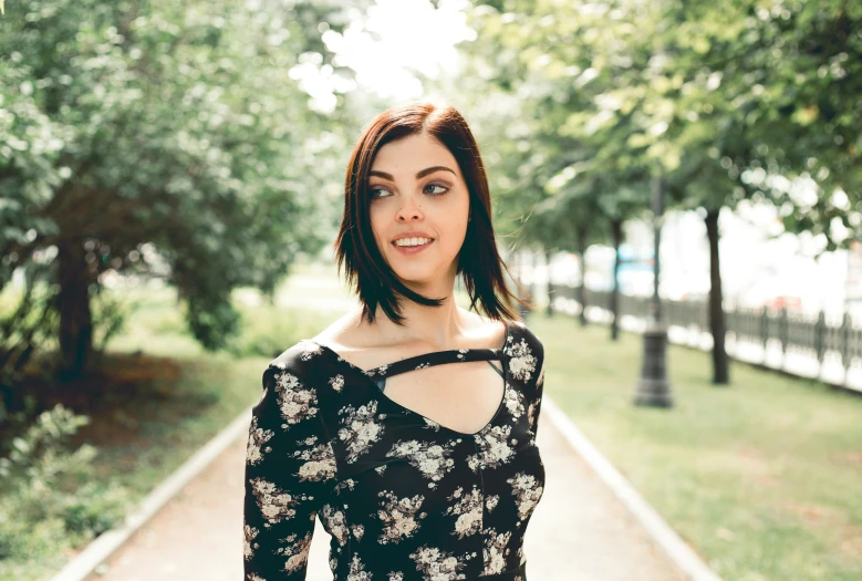 a woman in a black and white floral print dress is smiling