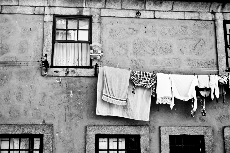 cloths and towels hanging on a wire outside a window