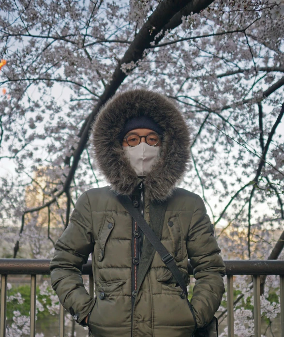 a man is wearing a hood and mask to keep warm