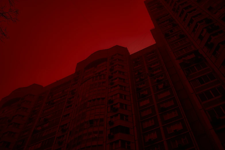 red clouds in a red sky behind tall buildings