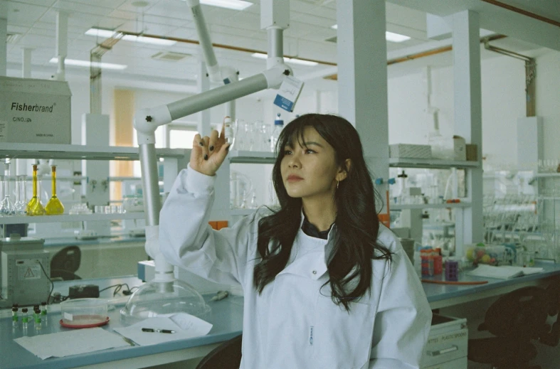 woman standing in laboratory looking at a tube with liquid coming out