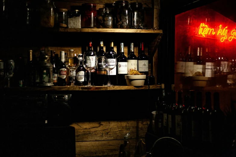 bottles of wine and wine glasses on wooden shelves