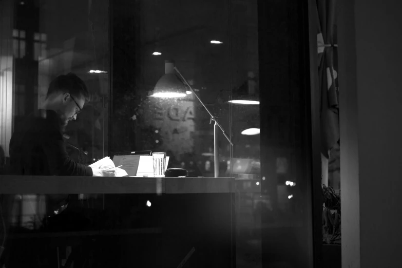 a woman that is sitting at a desk in front of a window