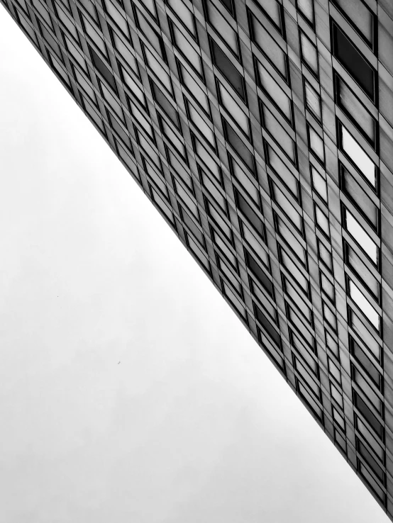 a tall building with some windows and white clouds