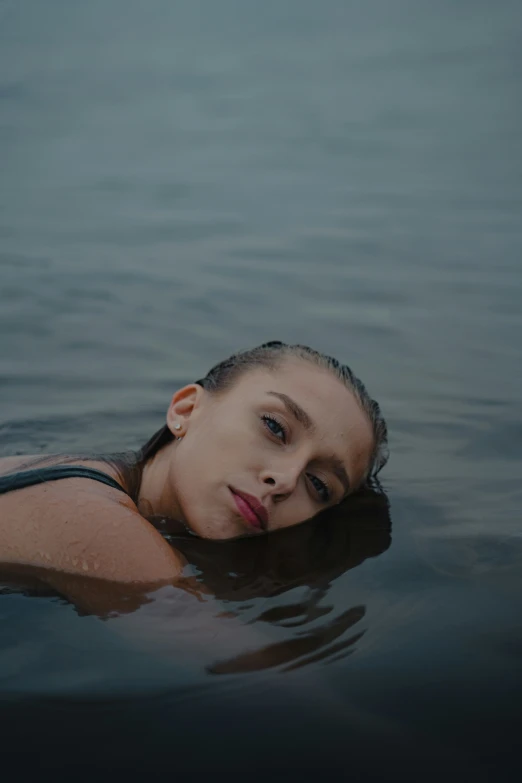 a beautiful young lady floating on top of water