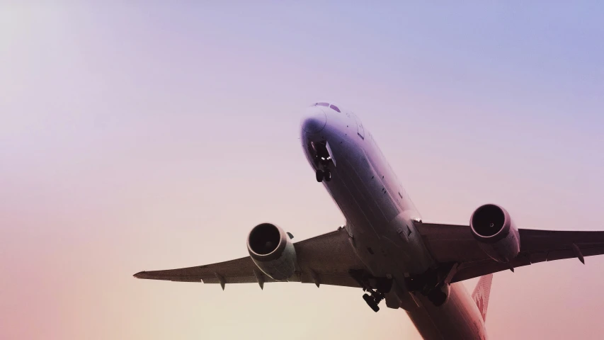 a large jetliner flying through a purple sky