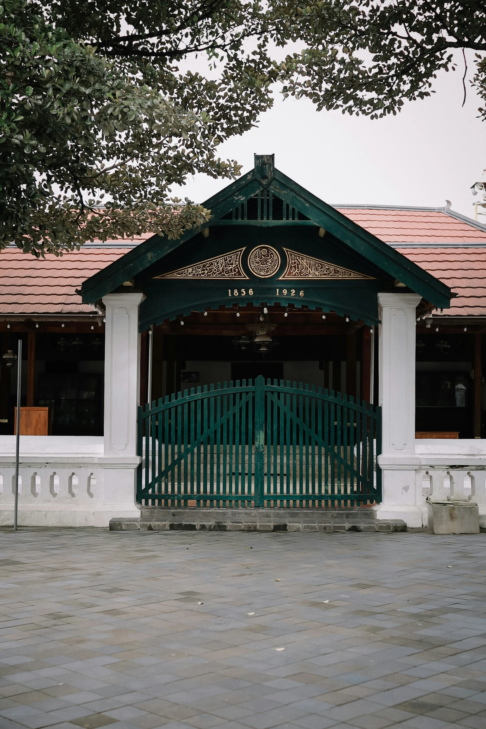 a white fence with a green gate on top