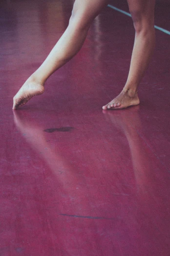 someone's bare toes and leg are visible in the middle of a red floor