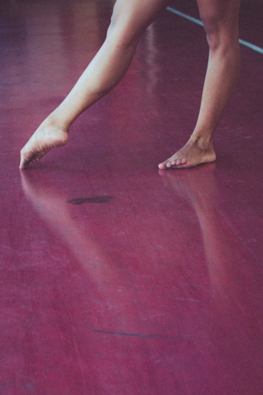 someone's bare toes and leg are visible in the middle of a red floor