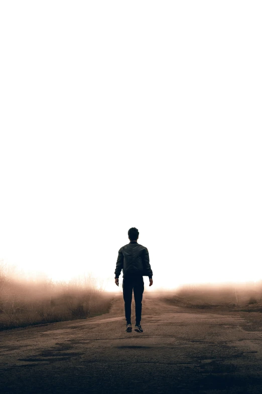 man walking away from camera in an open landscape