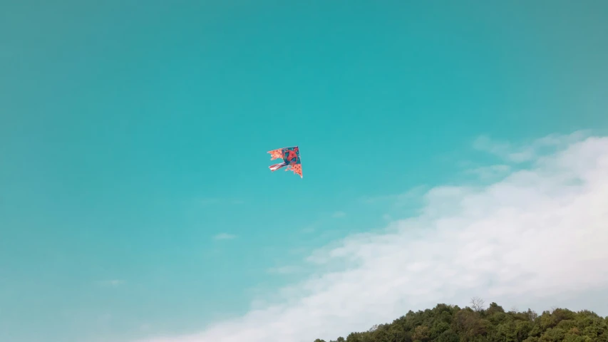a kite is soaring in the blue sky
