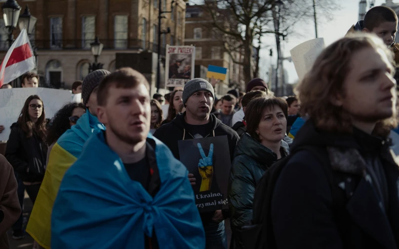 a crowd of people holding signs on a street