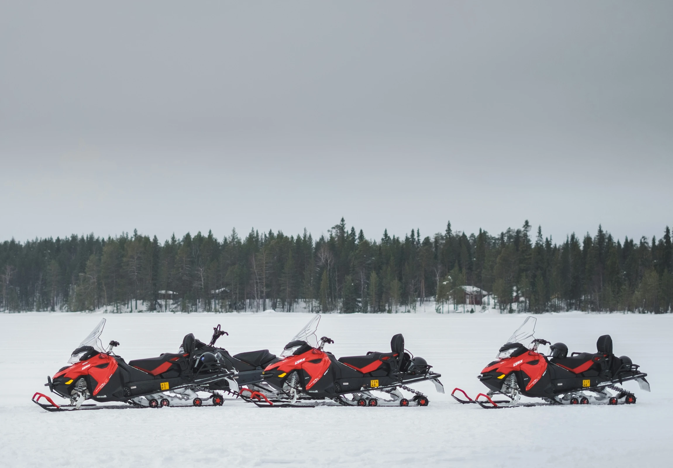 a group of snowmobiles driving in the snow