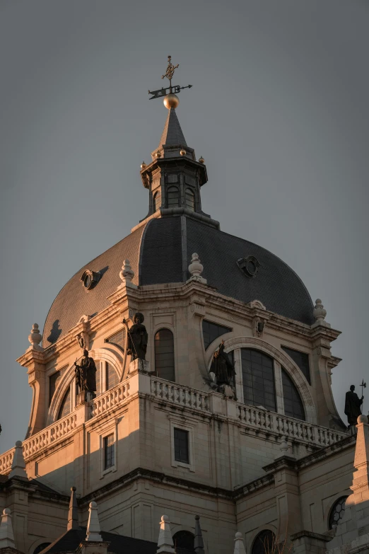 the steeple of a tall building with statues