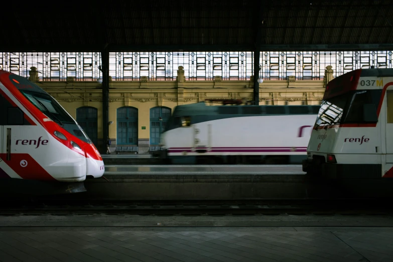 two trains stopped at the train station while another waits