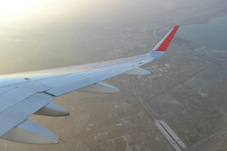 the tail end of an airplane flying over land