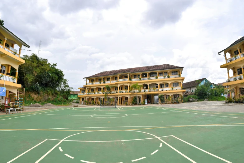 a small basketball court with multiple courts and people looking on