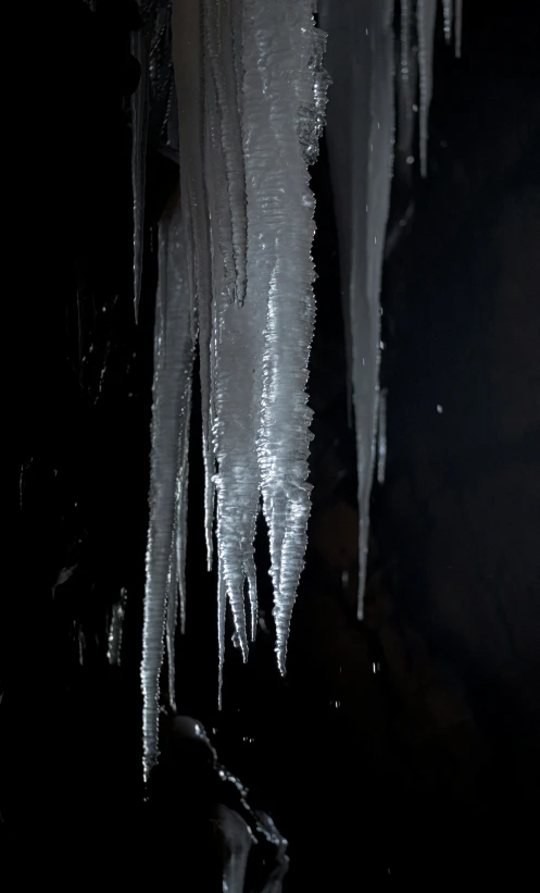 icicles hanging from a ceiling with dark background