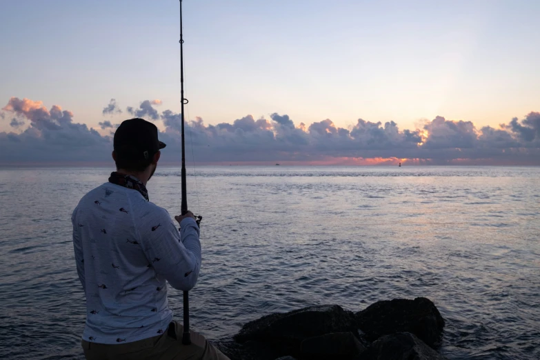 a person on a rock with a fishing rod