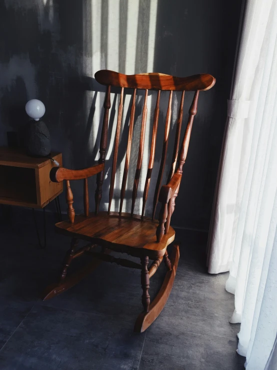 a rocking chair with wood trim in a dark room