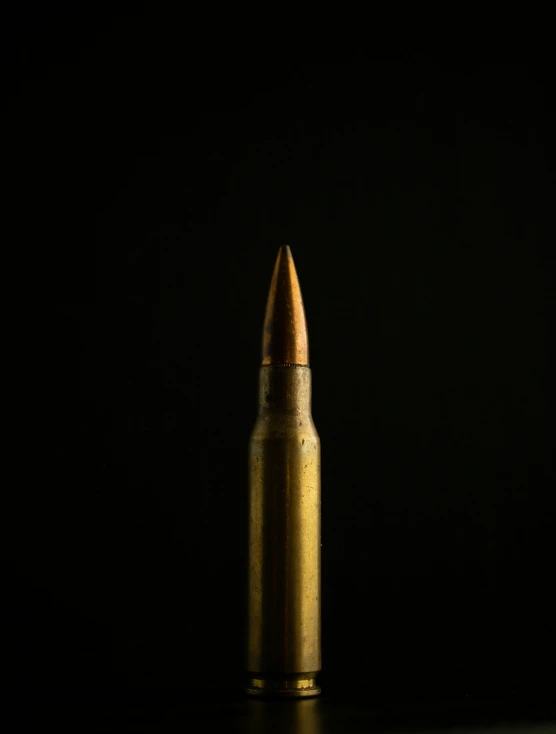 a close - up view of the gold bullet on a black surface