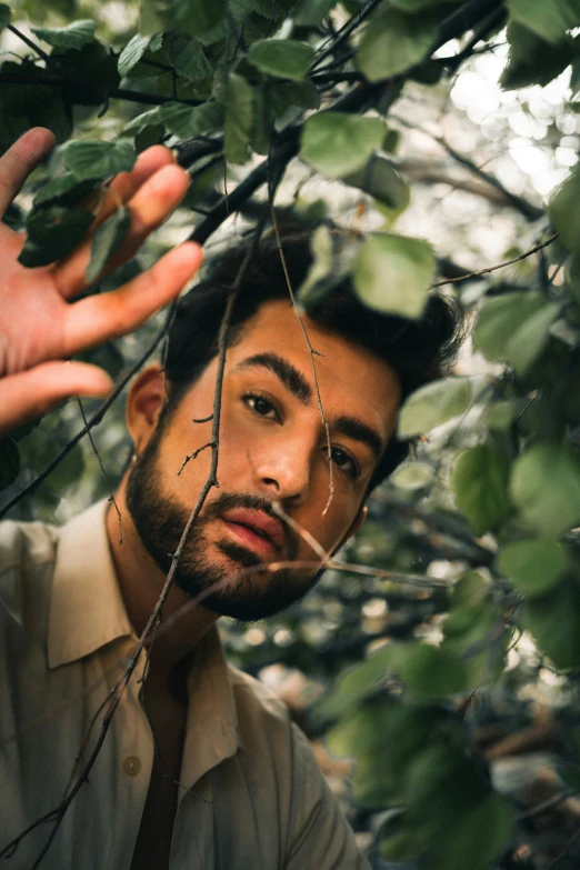 man with the eyes closed through foliage